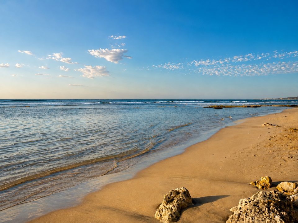 Low waves washing over sand and reef along the shoreline