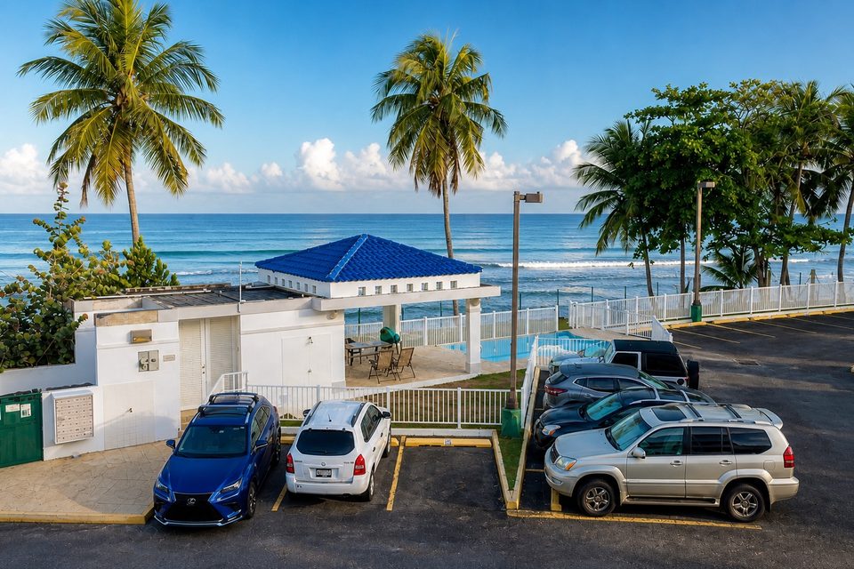 From the balcony: palms, the pool and gazebo, the parking court and the open ocean