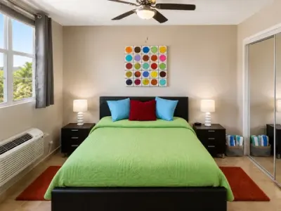 Segunda habitación: cama bajo un abanico de techo, aire acondicionado y ventana amplia