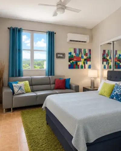 Altillo: sofá gris, cama preparada, cortinas turquesa y aire acondicionado propio