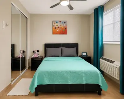 Primera habitación al anochecer, con ropa de cama verde menta y lámparas encendidas